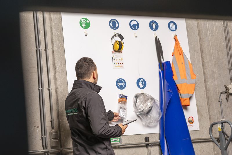 Adviseur van Prevensa controleert het bord met persoonlijke beschermingsmiddelen
